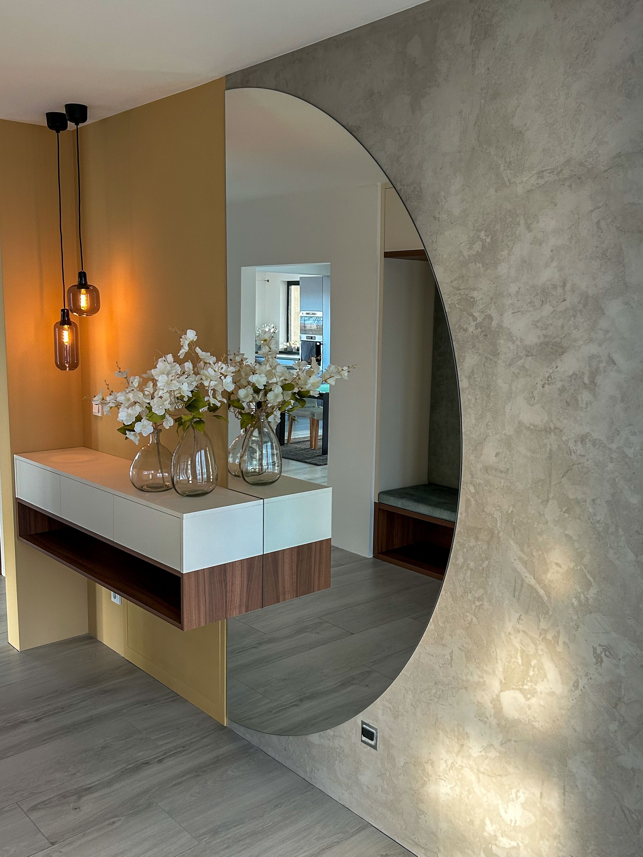Realizovaná předsíň s betonovou stěrkou a designovým zrcadlem
