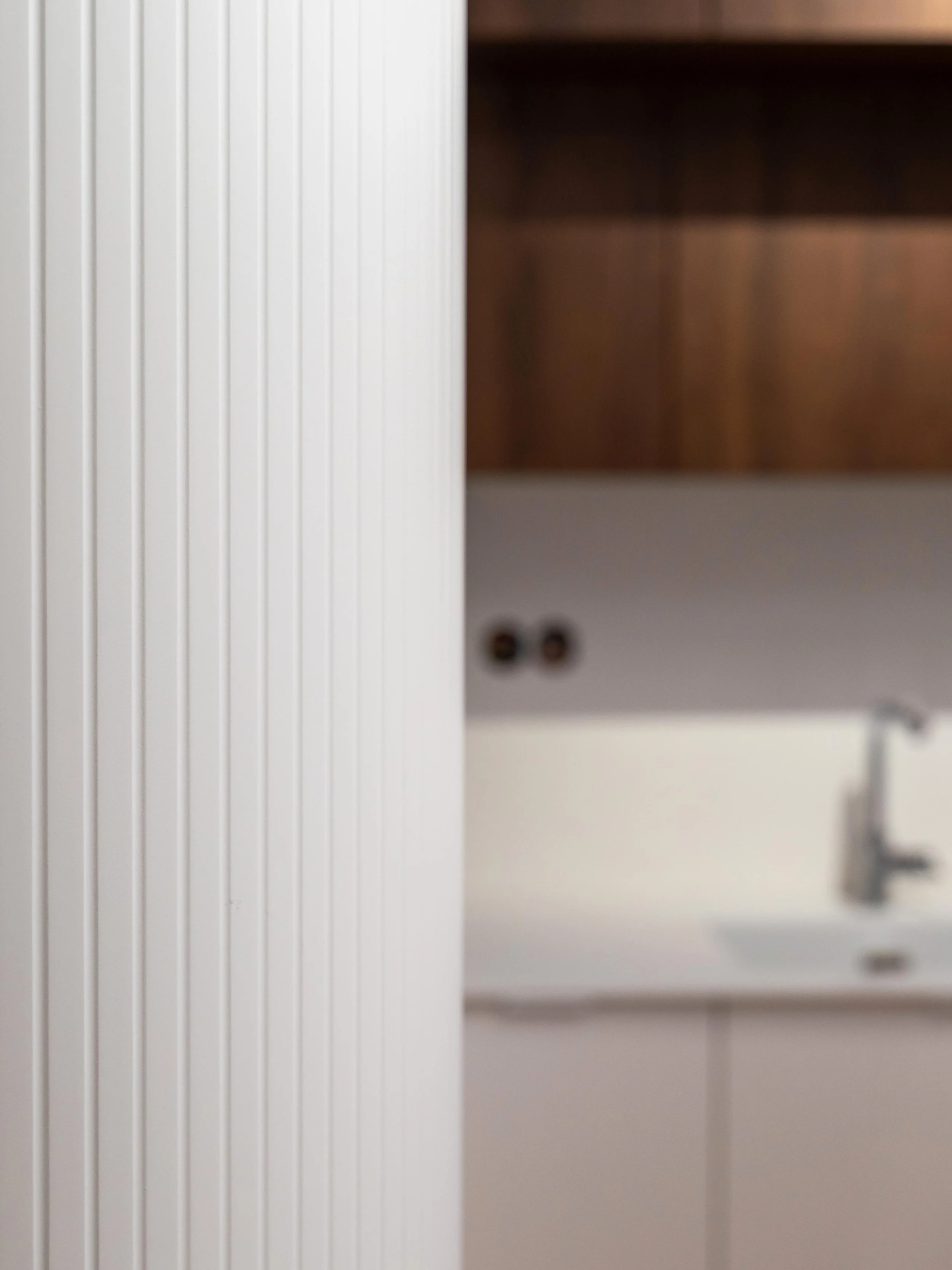 Detail kuchyňských dvířek s vyfrézovanými drážkami a jemným sofistikovaným designem