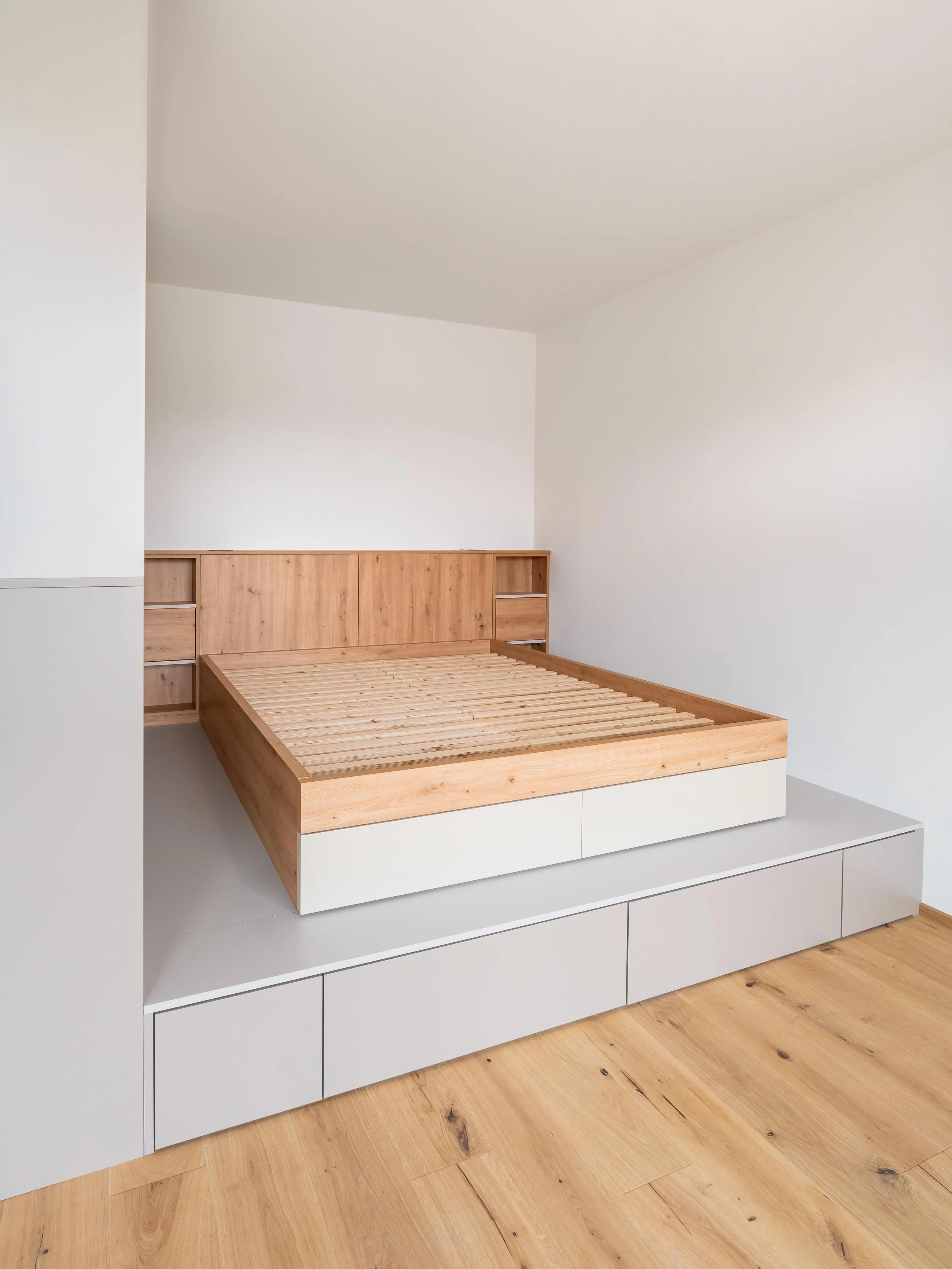 Detail spací části s nočními stolky a harmonickým designem v dekoru dub divoký