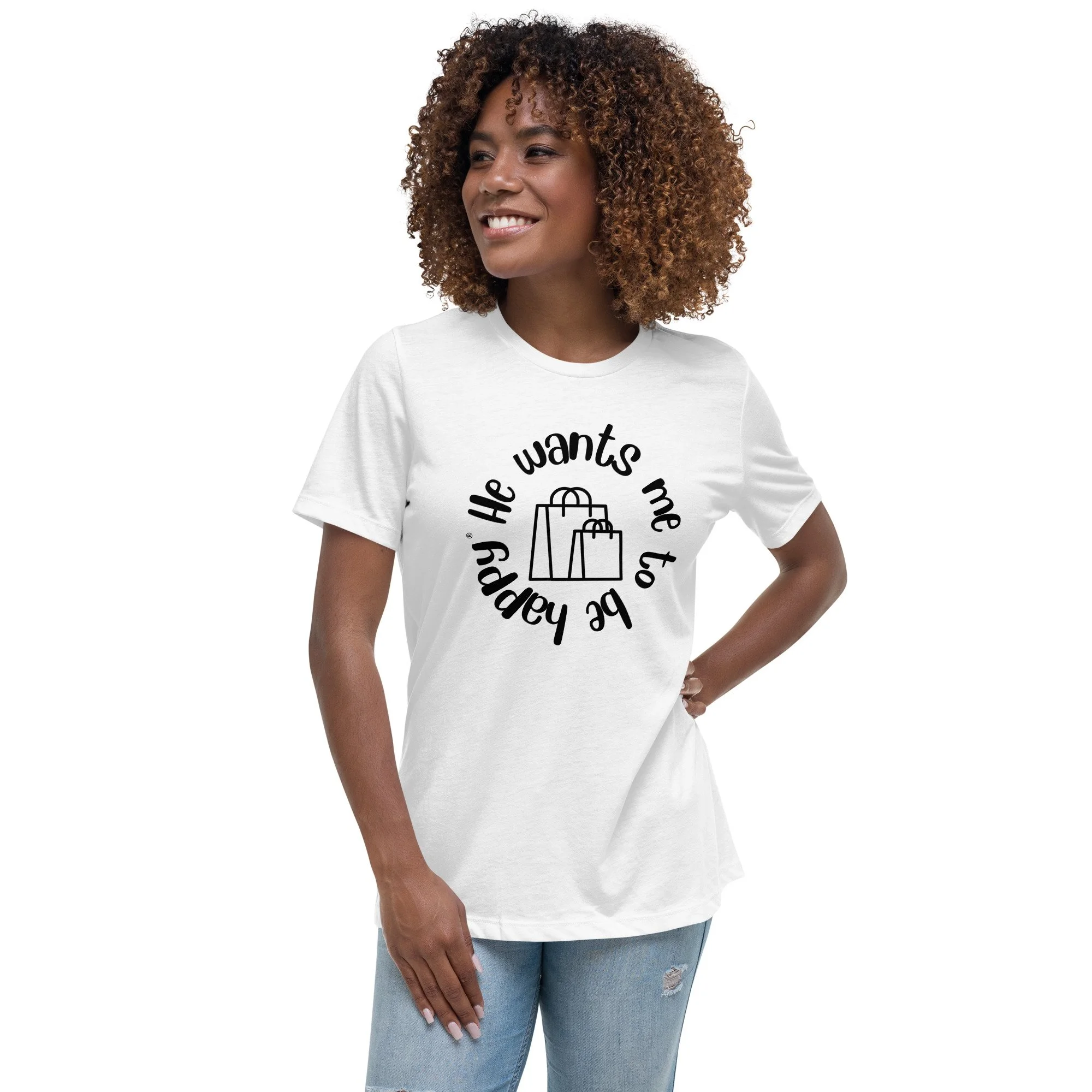 A woman with curly brown hair smiling, wearing a white T-shirt with black text and blue jeans.