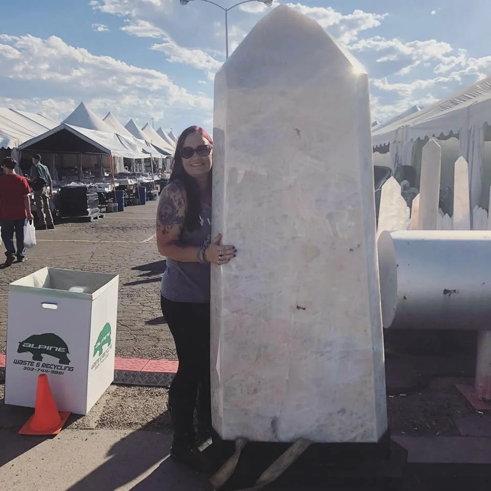DaNae Sweet hugging a giant quartz tower at the Denver Gem Show.