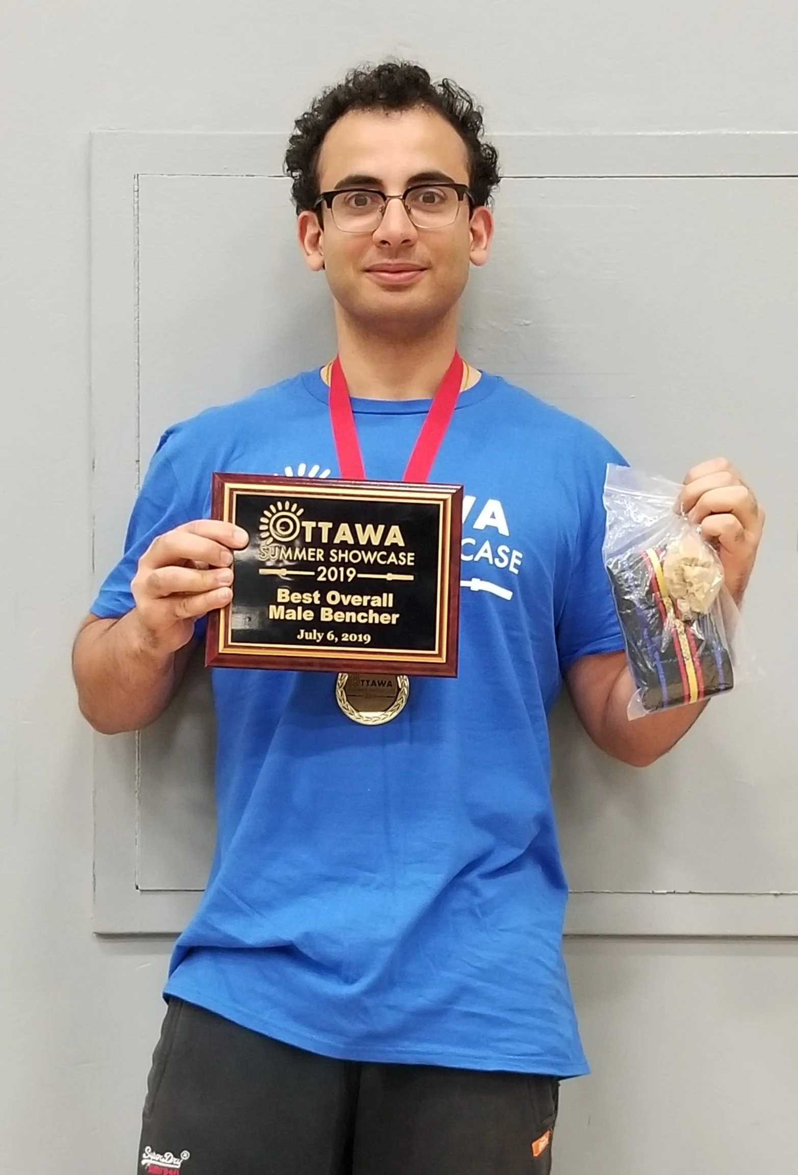 Ishan Verma wearing a medal and holding an award.
