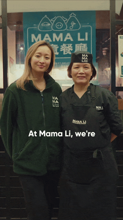 Two women standing inside a restaurant called Mama Li. One woman is wearing a green hoodie, and the other is dressed in a black chef's uniform with a hat. There is a Mama Li sign behind them.
