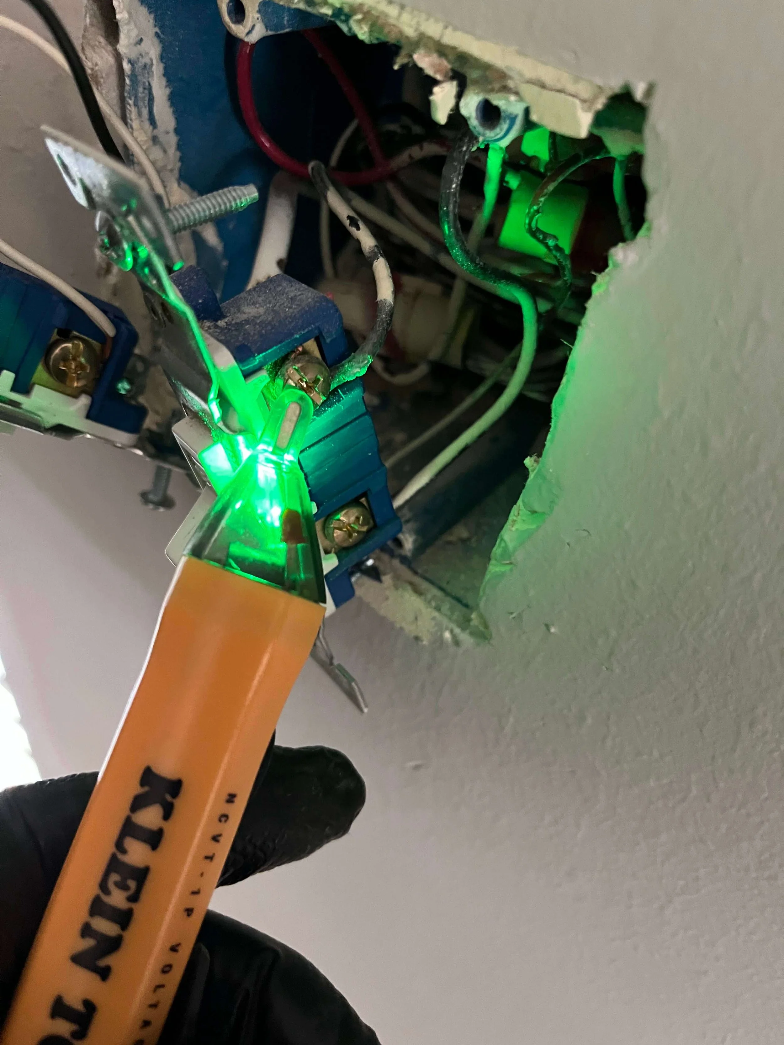 Professional handyman using a voltage tester to verify power is off before an electrical repair in St. Charles.
