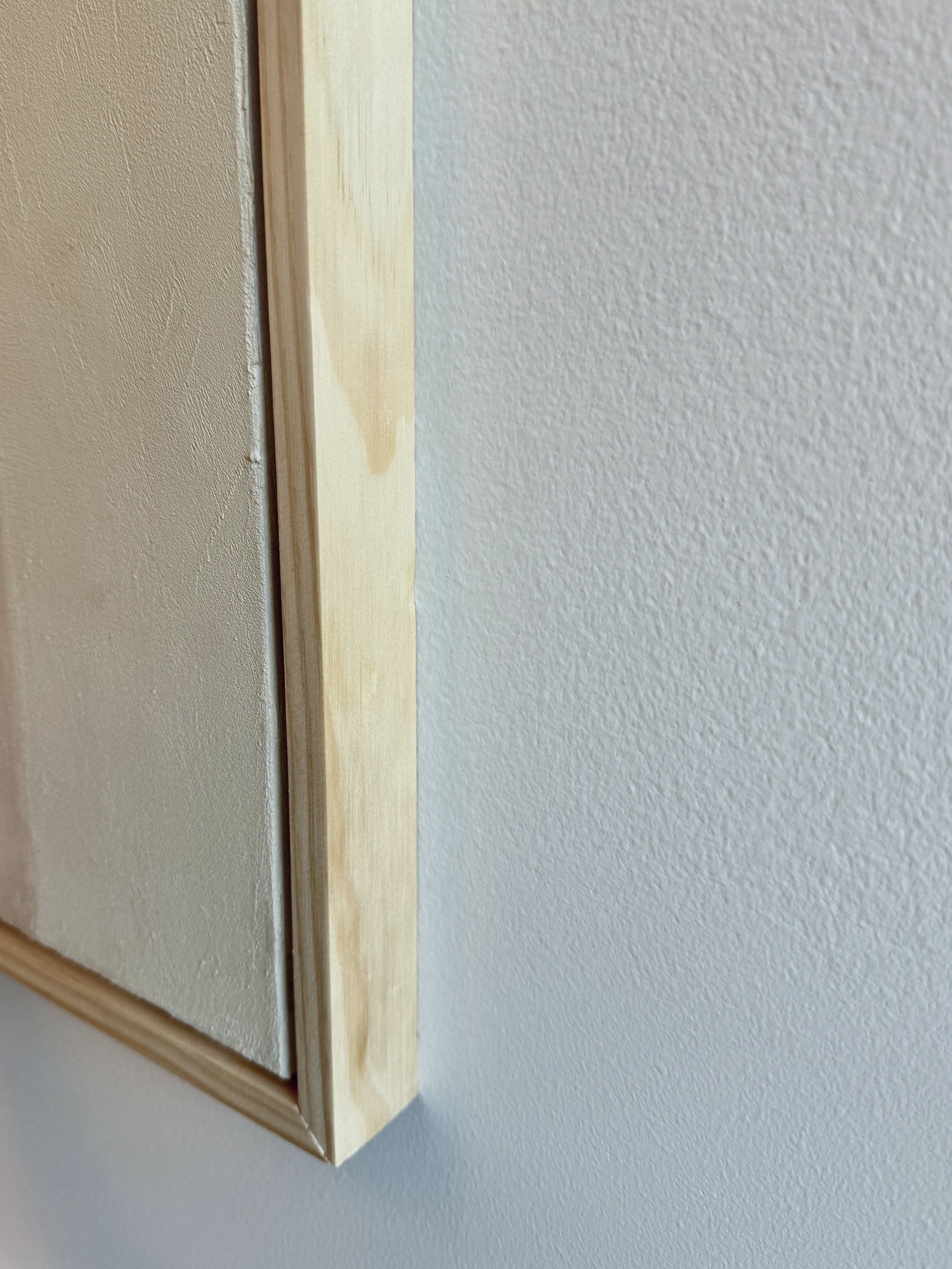 Side view of Worth the Trip showcasing the natural wood frame and the lightly textured surface of the painting.