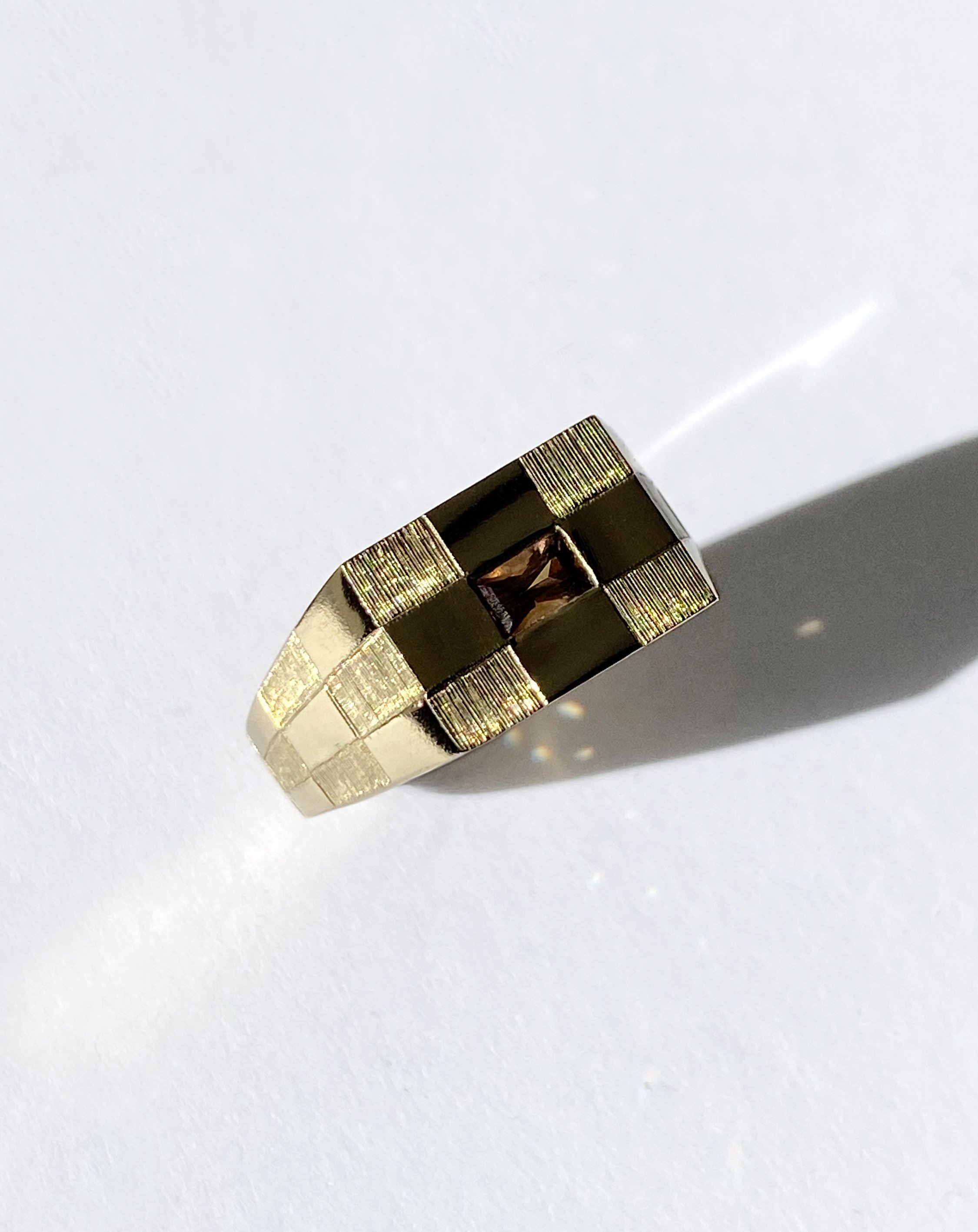 Engraved gold ring with a checked square design with a central coffee coloured Madagascan sapphire.