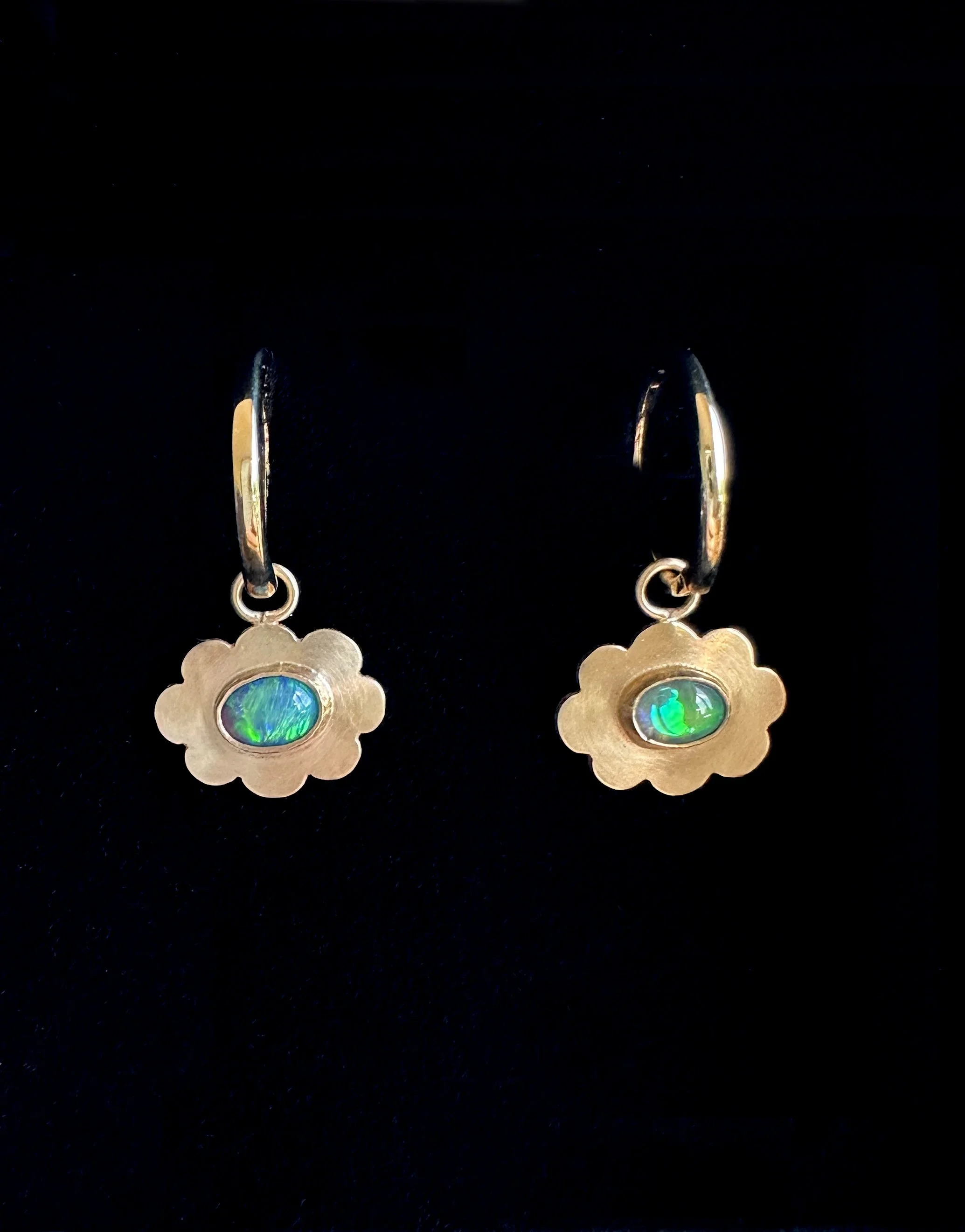 Gold earrings with floral design and green opal stones.