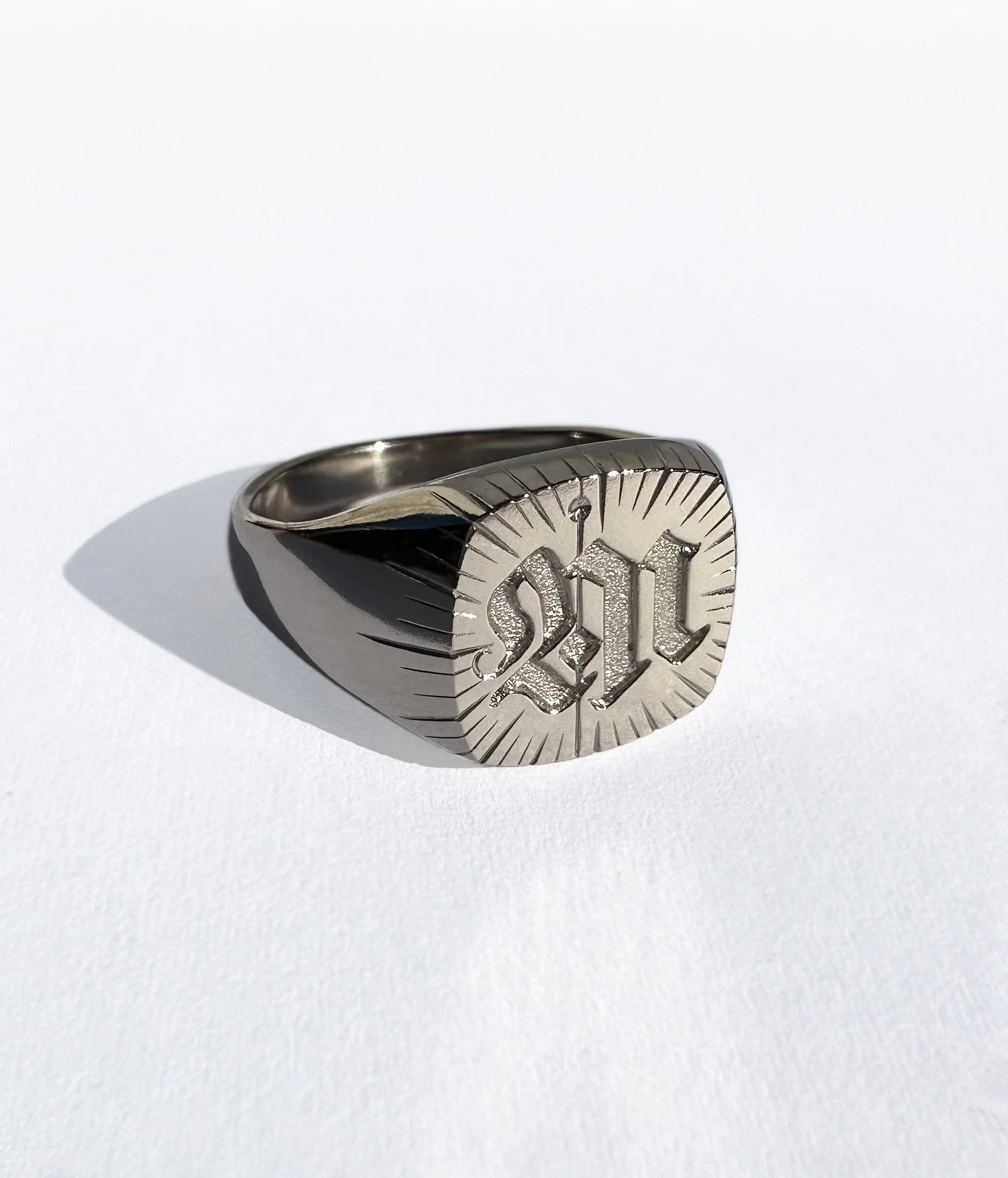 18ct white gold ring with engraved with a letter 'M' in gothic script.