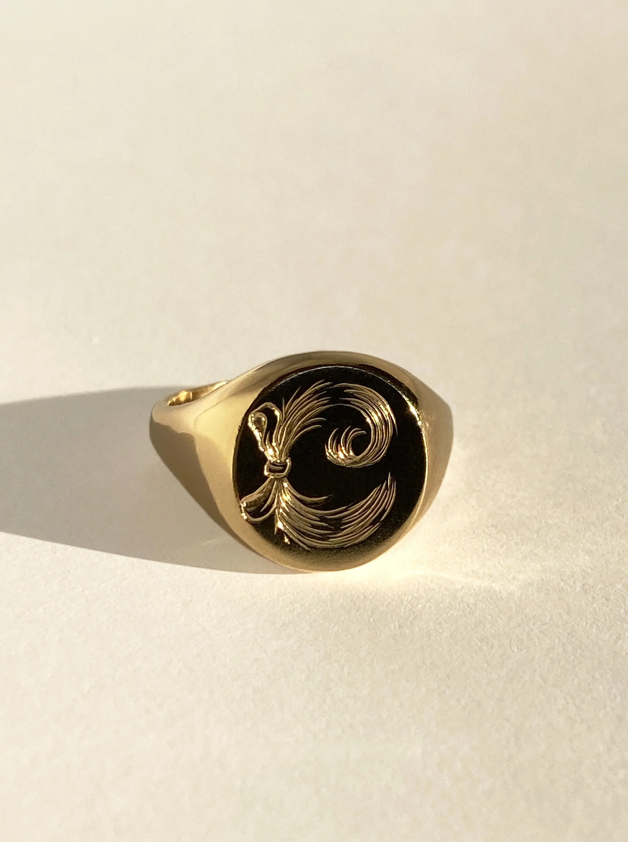 18 k gold signet ring with an engraved design of hair clipping.