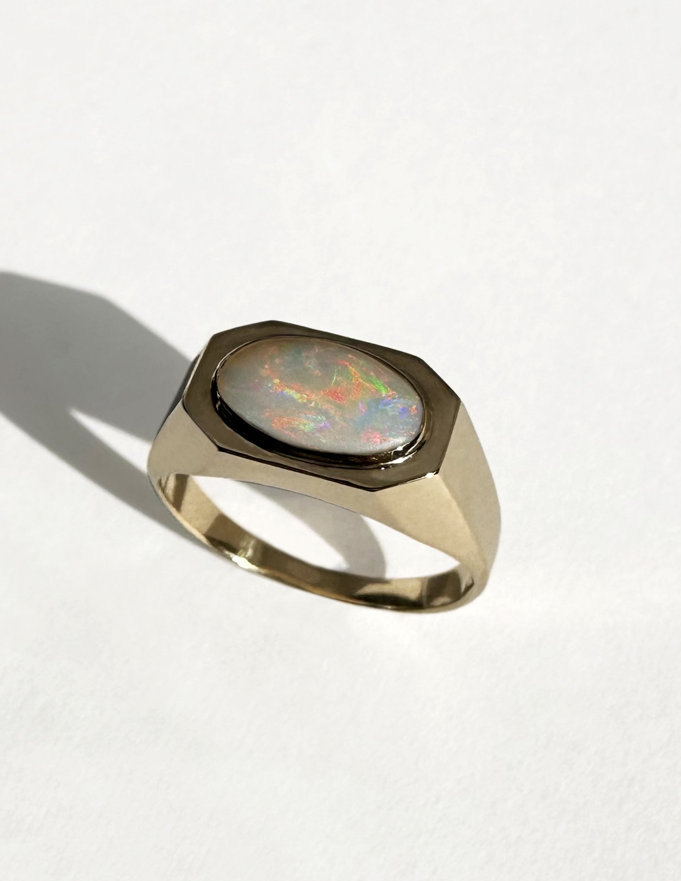 Gold ring with an oval opal gemstone.