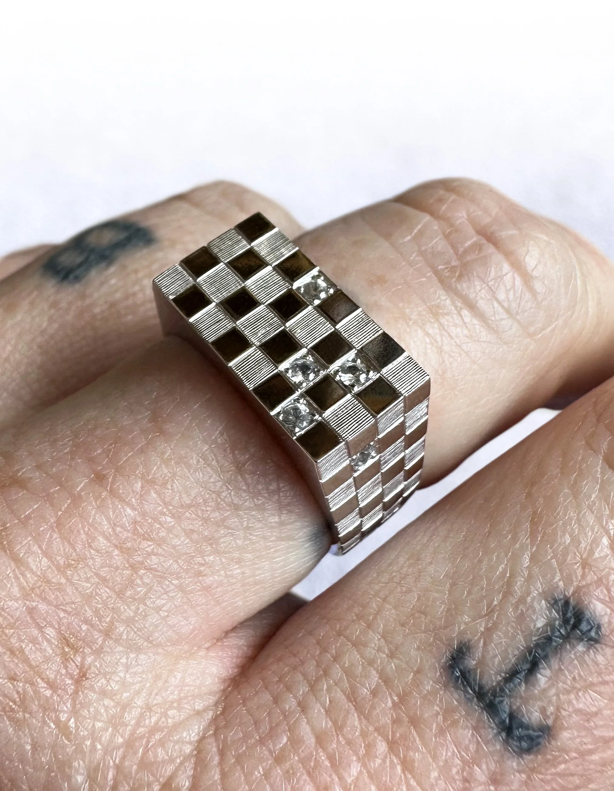 18k white gold engraved checked wedding band, featuring pavé set white sapphires.