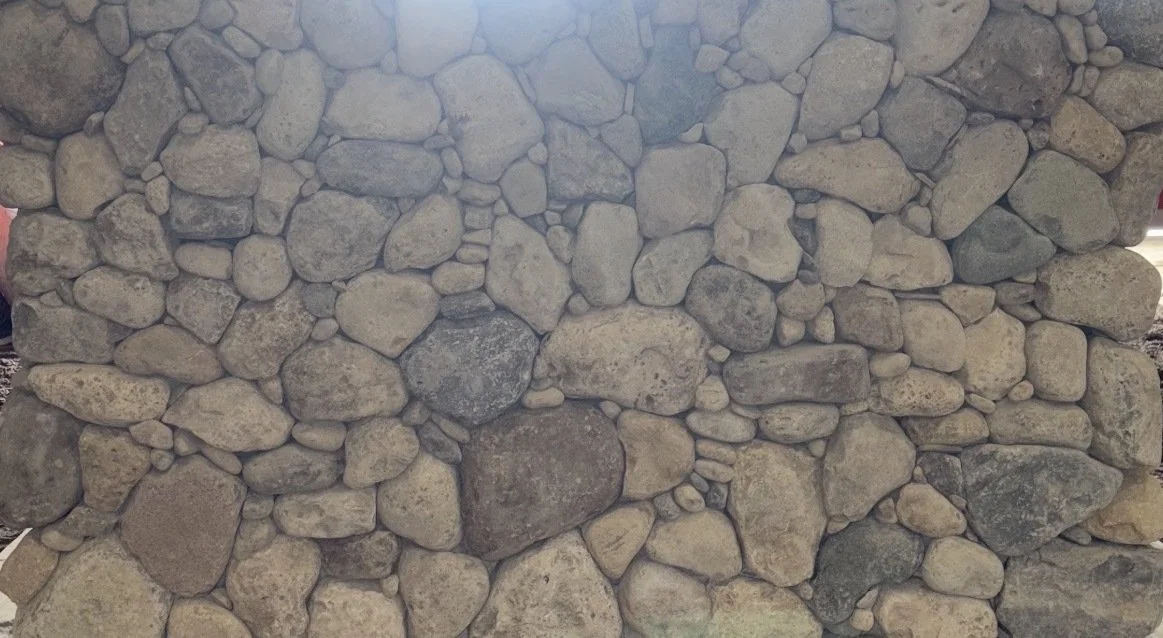 Close-up of a stack of irregularly shaped stones in various shades of gray and beige.