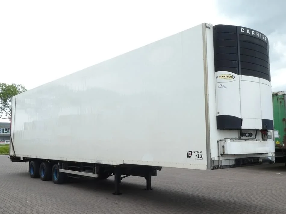 A large white refrigerated semi-trailer truck with an empty cargo area and a black refrigeration unit at the front, parked on a paved surface.