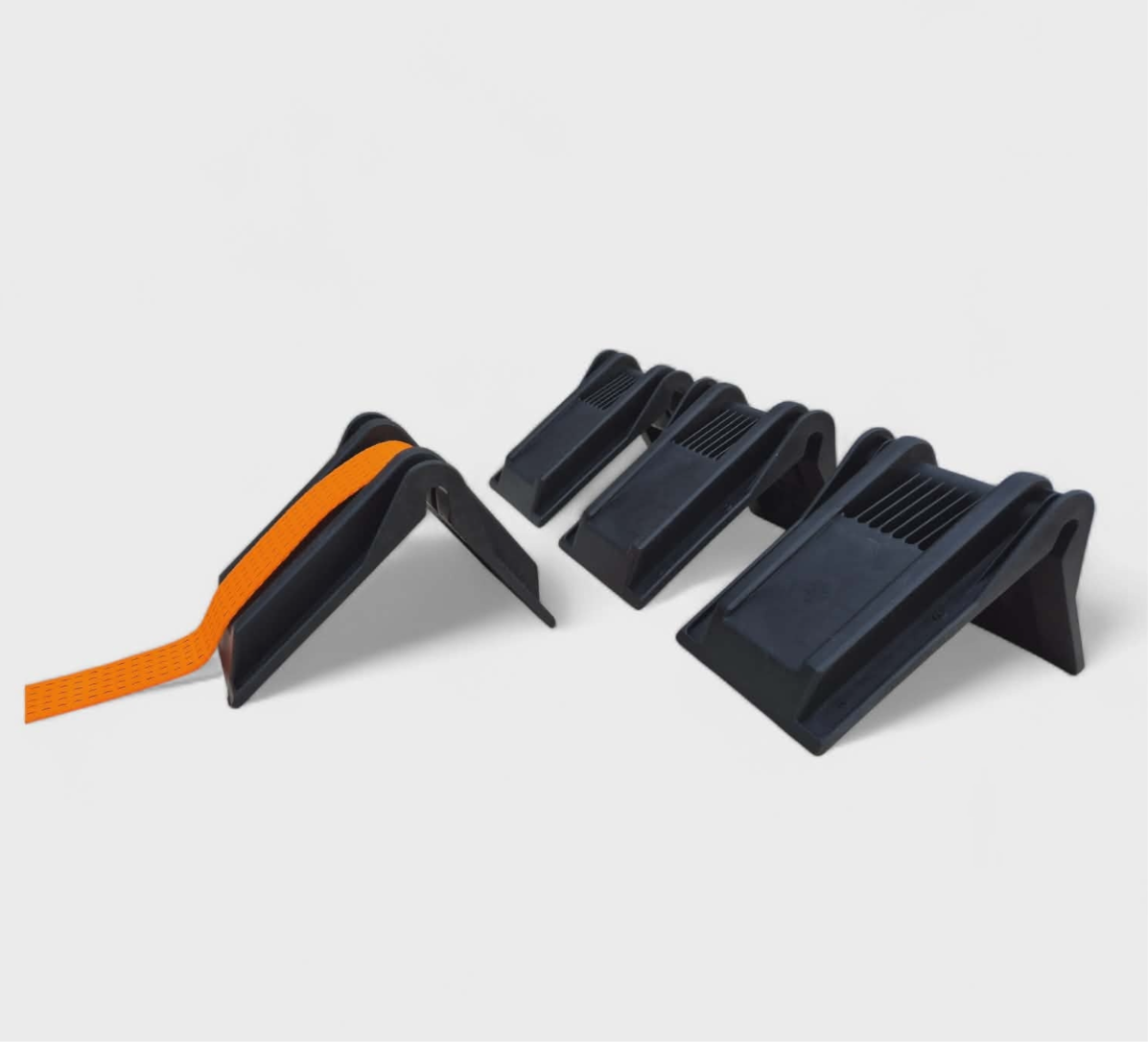 Set of four black skateboarding ramps with an orange skate strap.