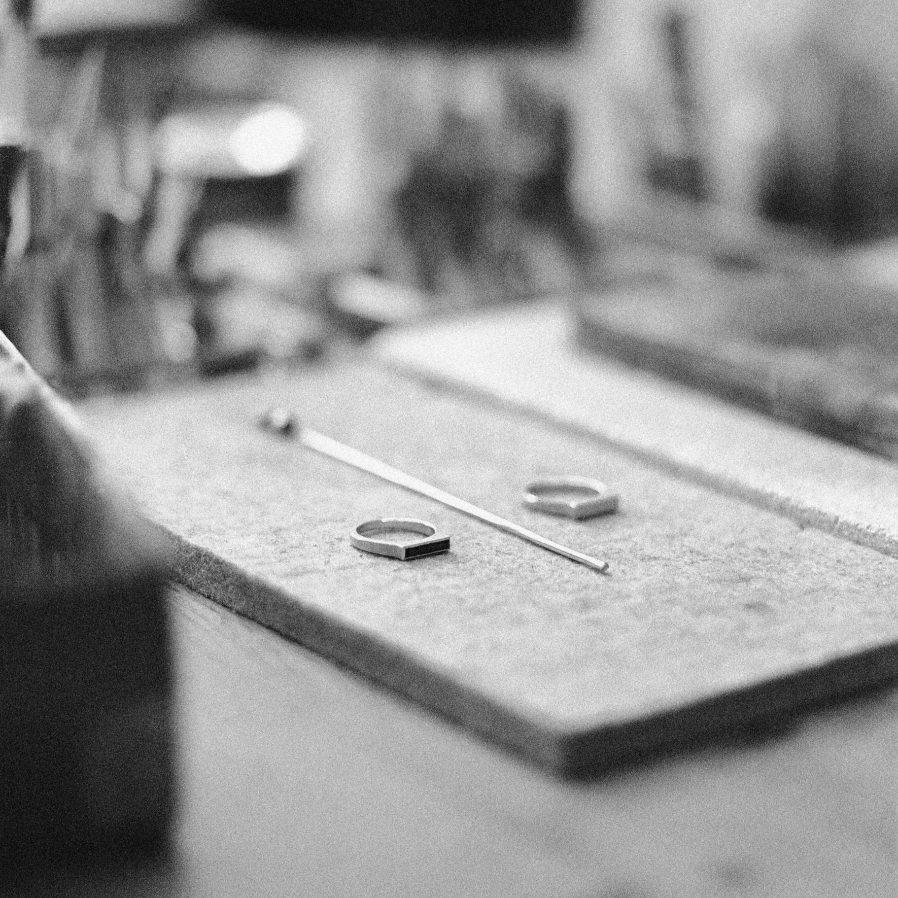 Schmuckherstellungswerkzeug auf einer Werkbank, Nahaufnahme in Schwarz-Weiß.