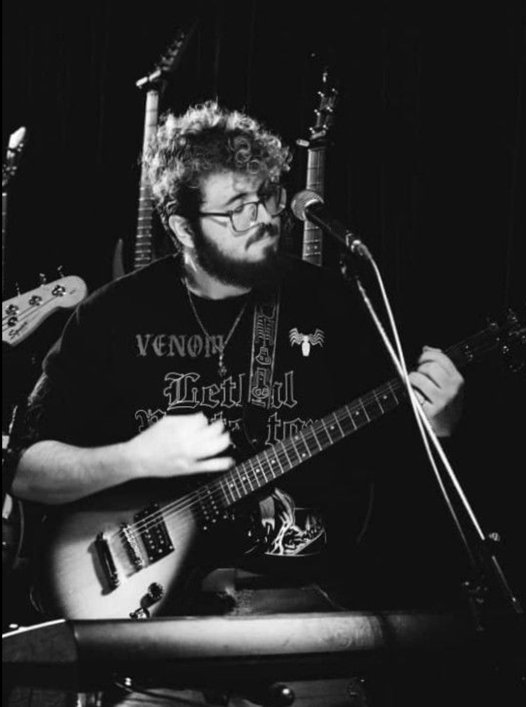 Photo of Ezra Goldberg playing electric guitar and singing.