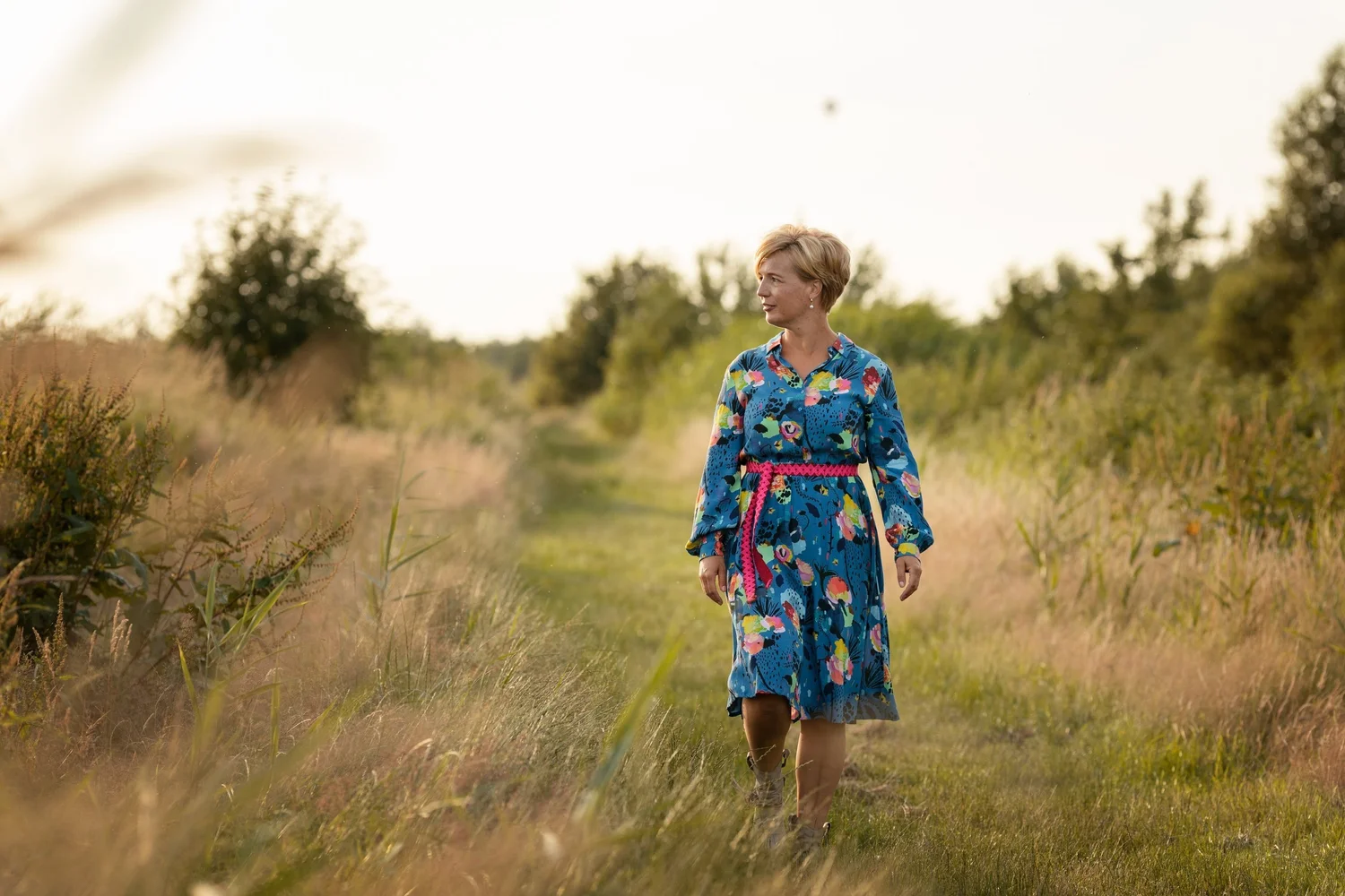 Rianne Sibma loopt door het hoge gras in het avondlicht
