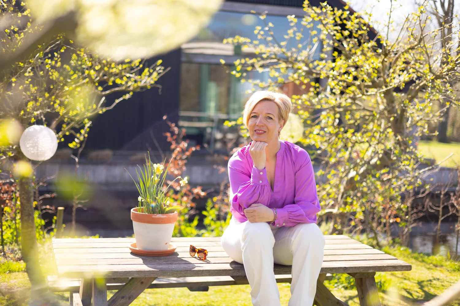 Rianne Sibma aan een tuintafel in Rottum, lachend