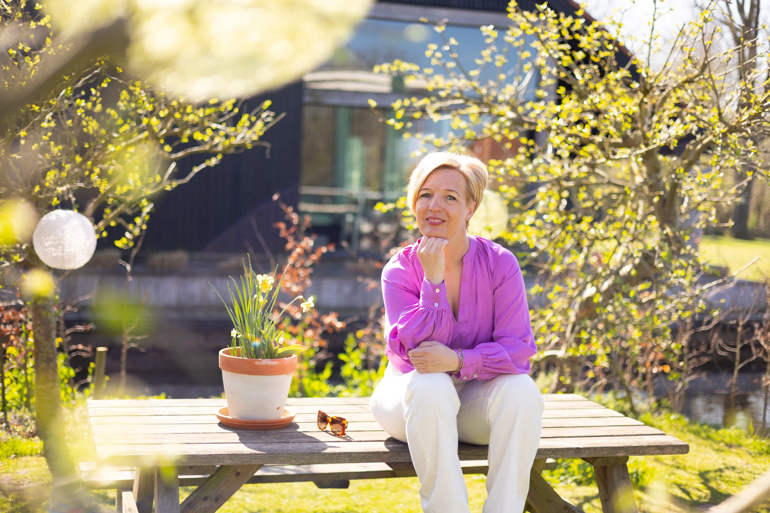 Rianne Sibma aan een tuintafel in Rottum, lachend