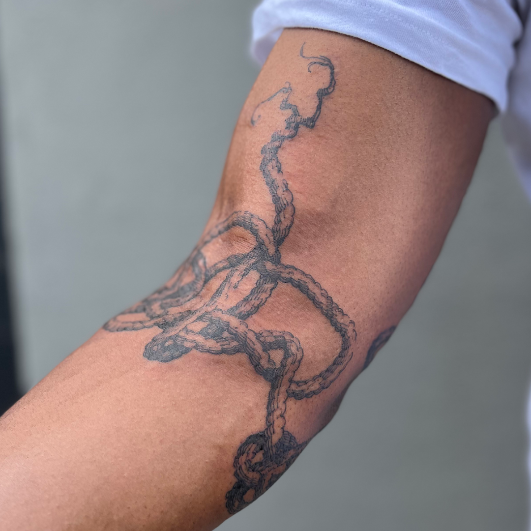 freehand rope tattoo around the elbow