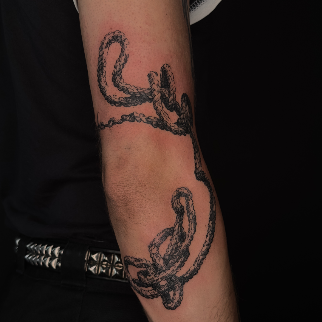 freehanded rope tattoo on the arm, elbow