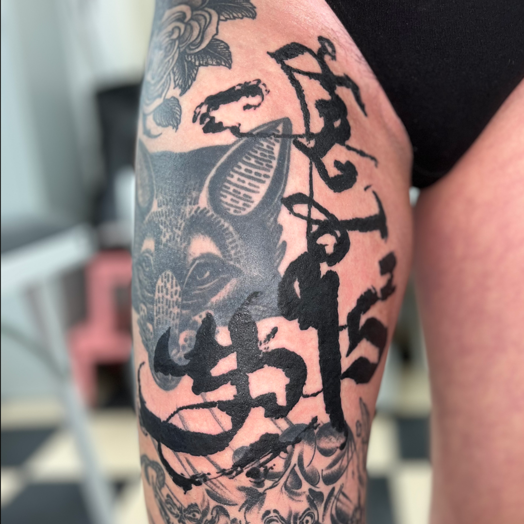 Custom abstract and asemic calligraphy tattoo on the upper thigh