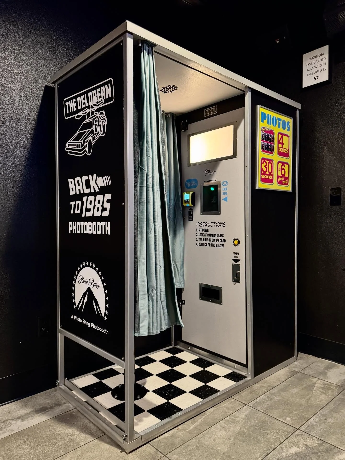 New photobooth location! @thedeloreandenver now has a Photo Bang booth! Inspired by Back to the Future, we have custom laser cut stainless door accents, checkered floor, teal seat and curtains and 80s/90s signage with a custom laser backdrop. Photos 