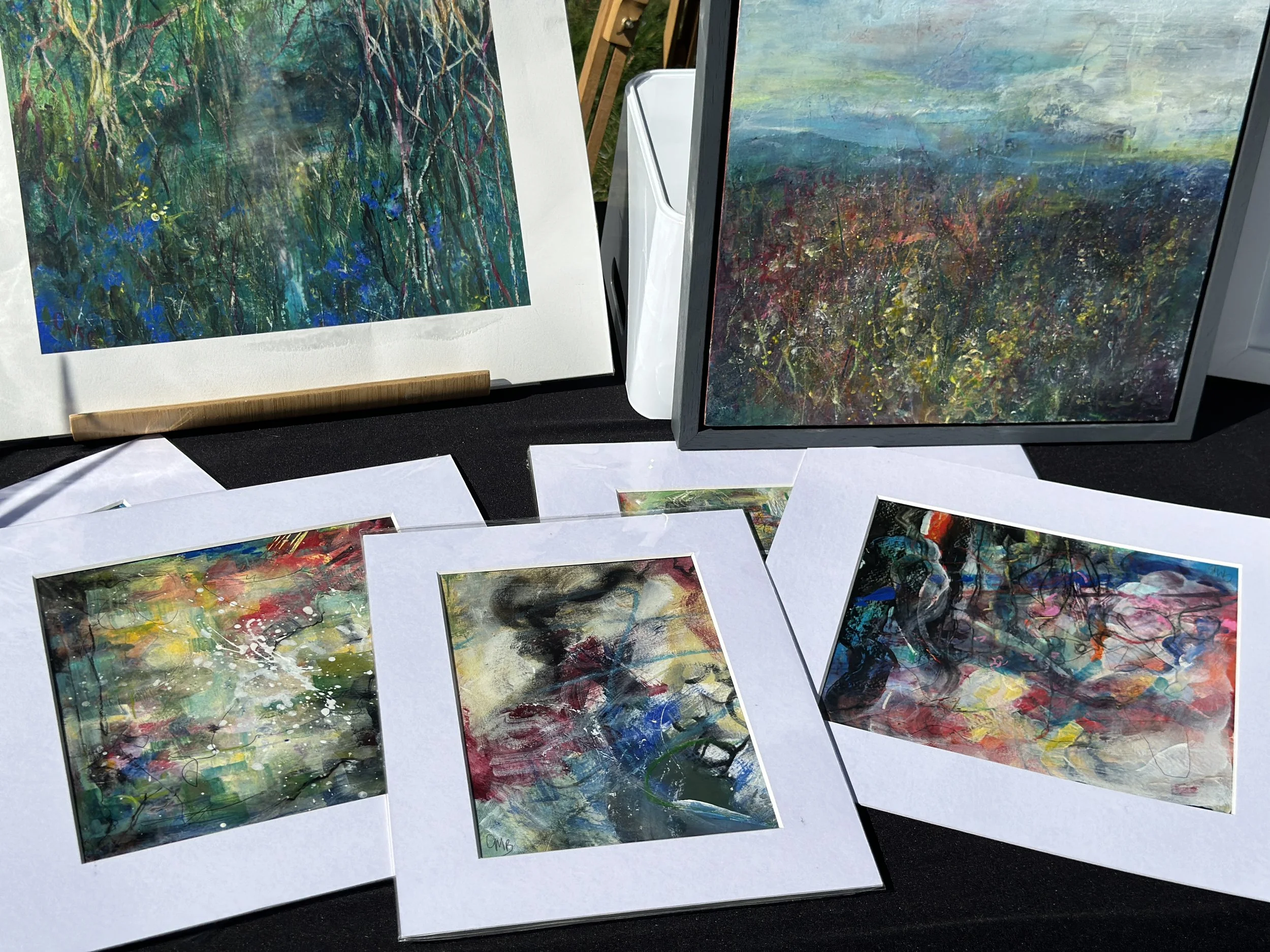 Display of Artwork by Catherine Burbridge on a black table with easel behind the table