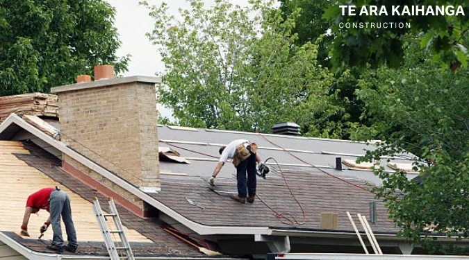 Construction worker fixing roof of a house