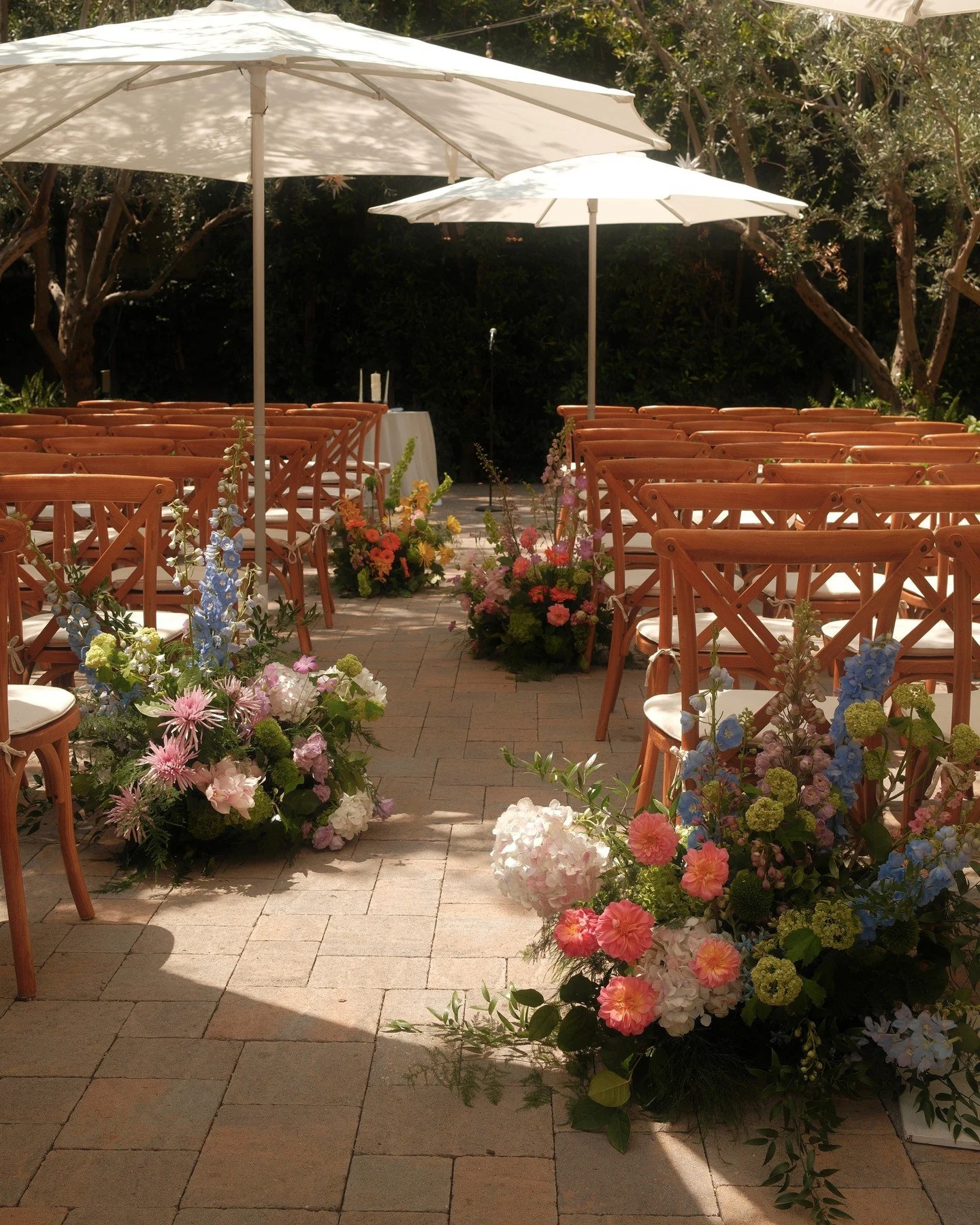 Whimsical garden wedding ceremony florals lining the aisle. Hydrangea, dahlias and delphinium for A+J's wedding day 🤍