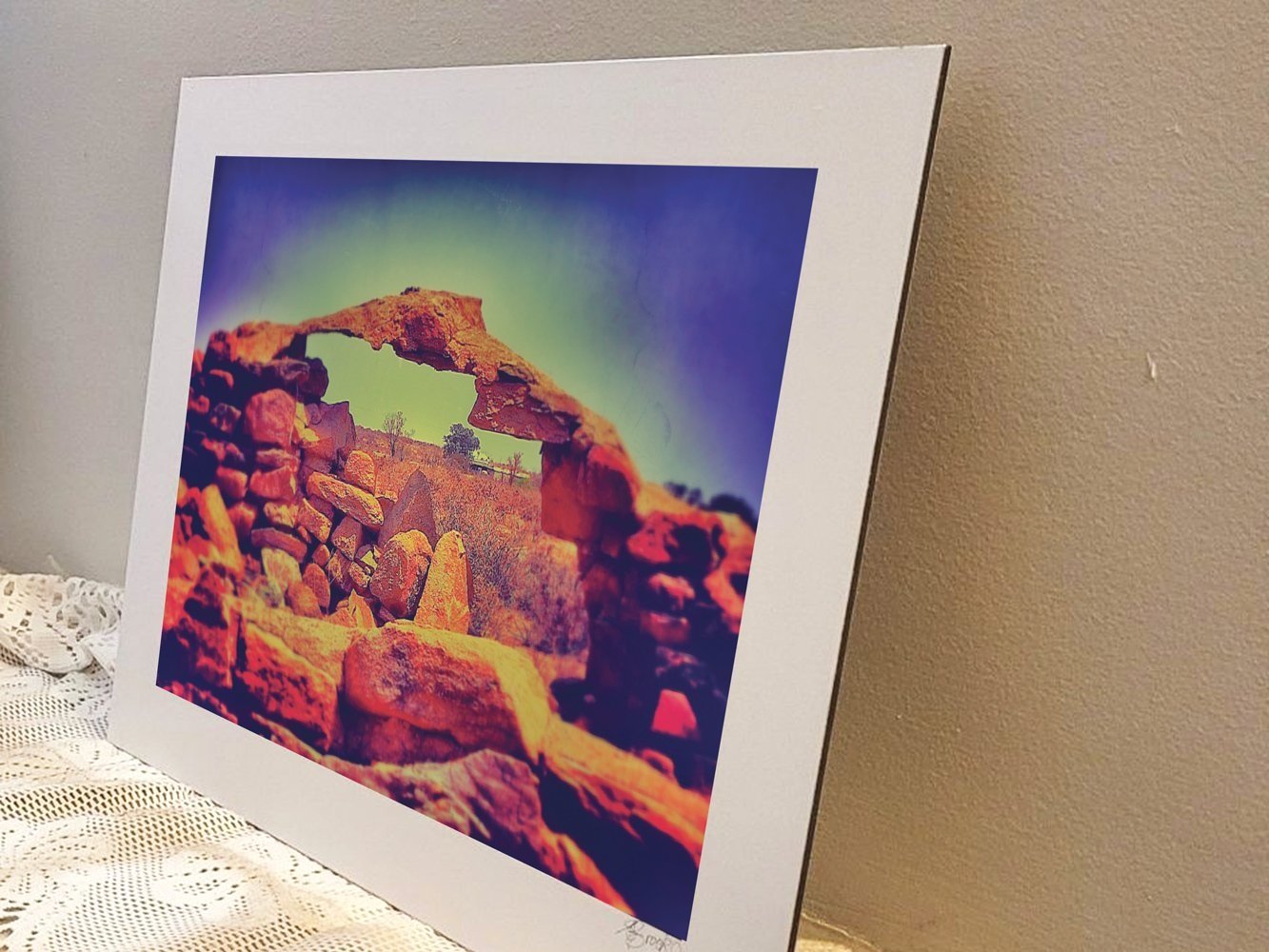 Metal backed photograph of ancient stone ruins with arched opening in outback Australia