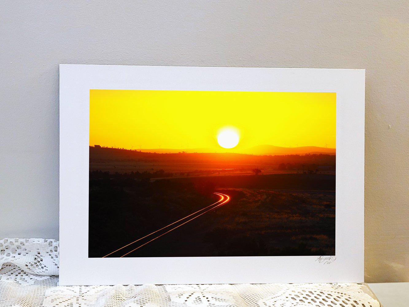 Metal backed photograph of a sunset over a railway in outback rural Australia
