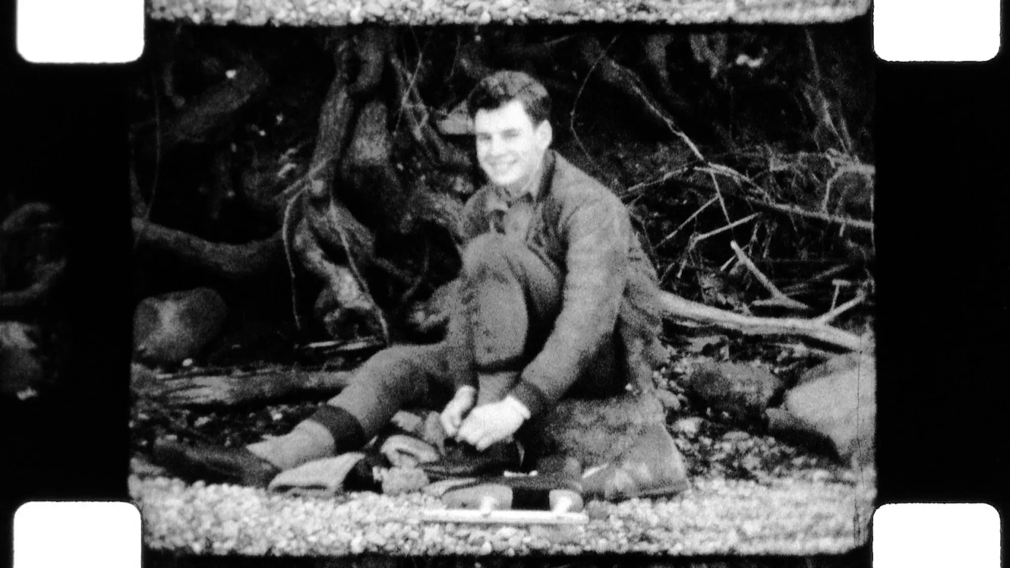 Jim Parmlee putting on ice skates, in black and white.