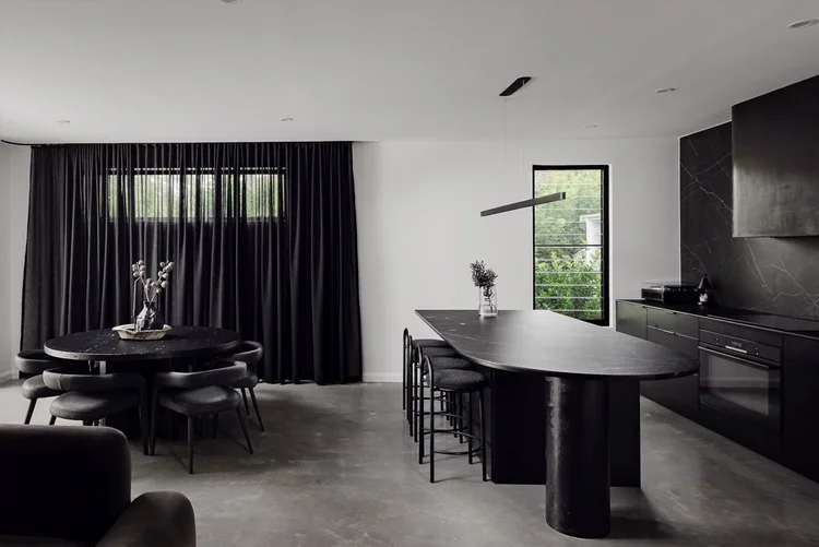 Dark kitchen and dining area with black joinery in the Huskisson project by CKS Projects