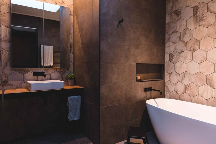 Bathroom with a freestanding bath, timber vanity and hexagon wall tiles at Ocean Windang