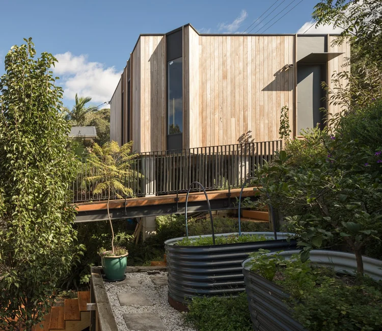 Timber-clad home with raised garden beds and established planting
