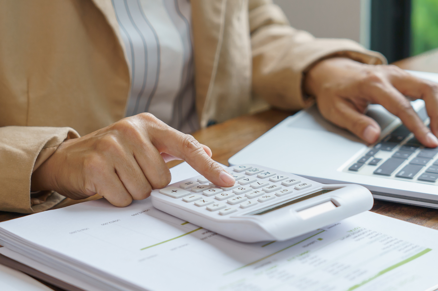 woman in corporate attire using  calculator