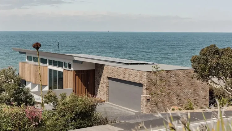 Stone and timber-clad clifftop home above the ocean at Wombarra, a CKS Projects knockdown rebuild