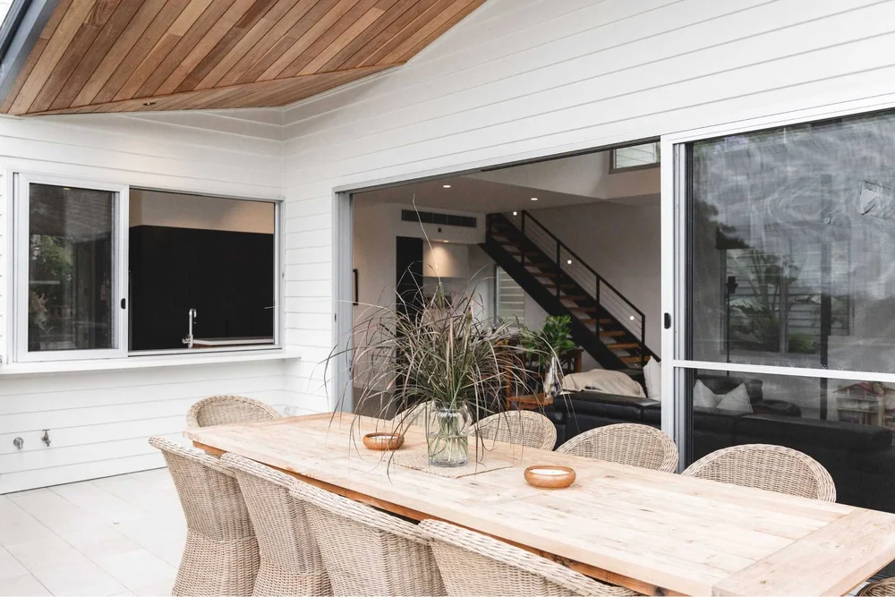 Dining area under a timber-lined ceiling with a staircase beyond, Sandhurst Bulli by CKS Projects