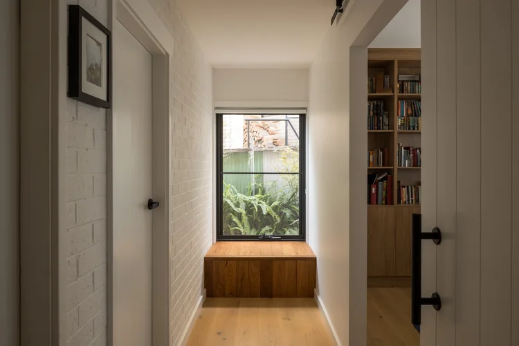Built-in timber window seat and recessed bookshelf joinery in a hallway, Coledale project