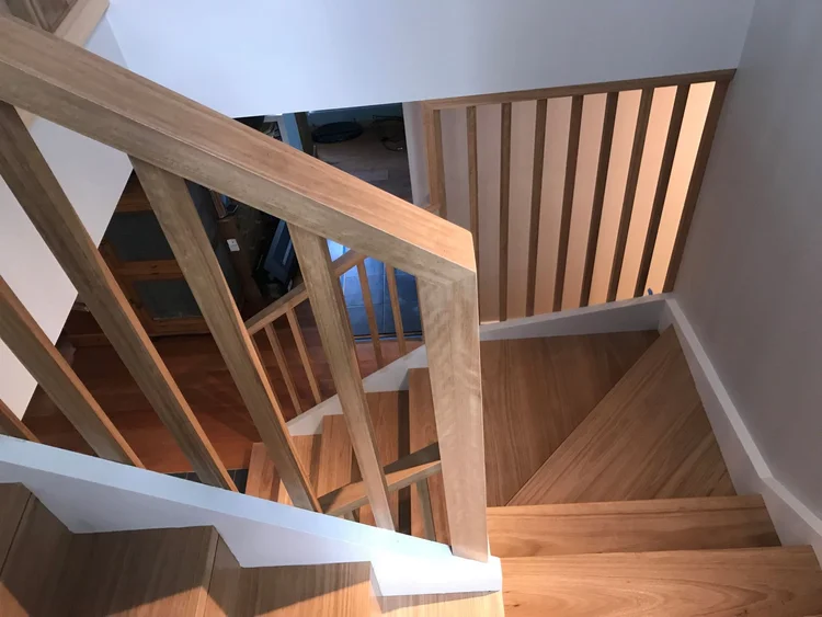 New timber staircase with vertical balusters connecting levels in the Wombarra addition
