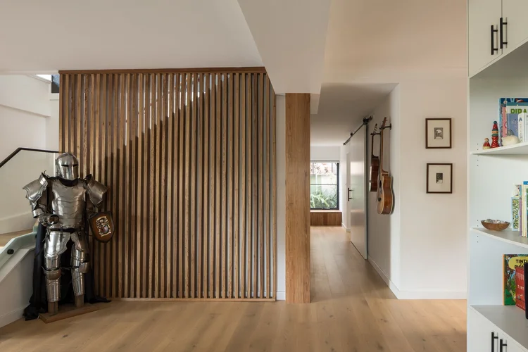 Hallway with a vertical timber batten screen and timber flooring