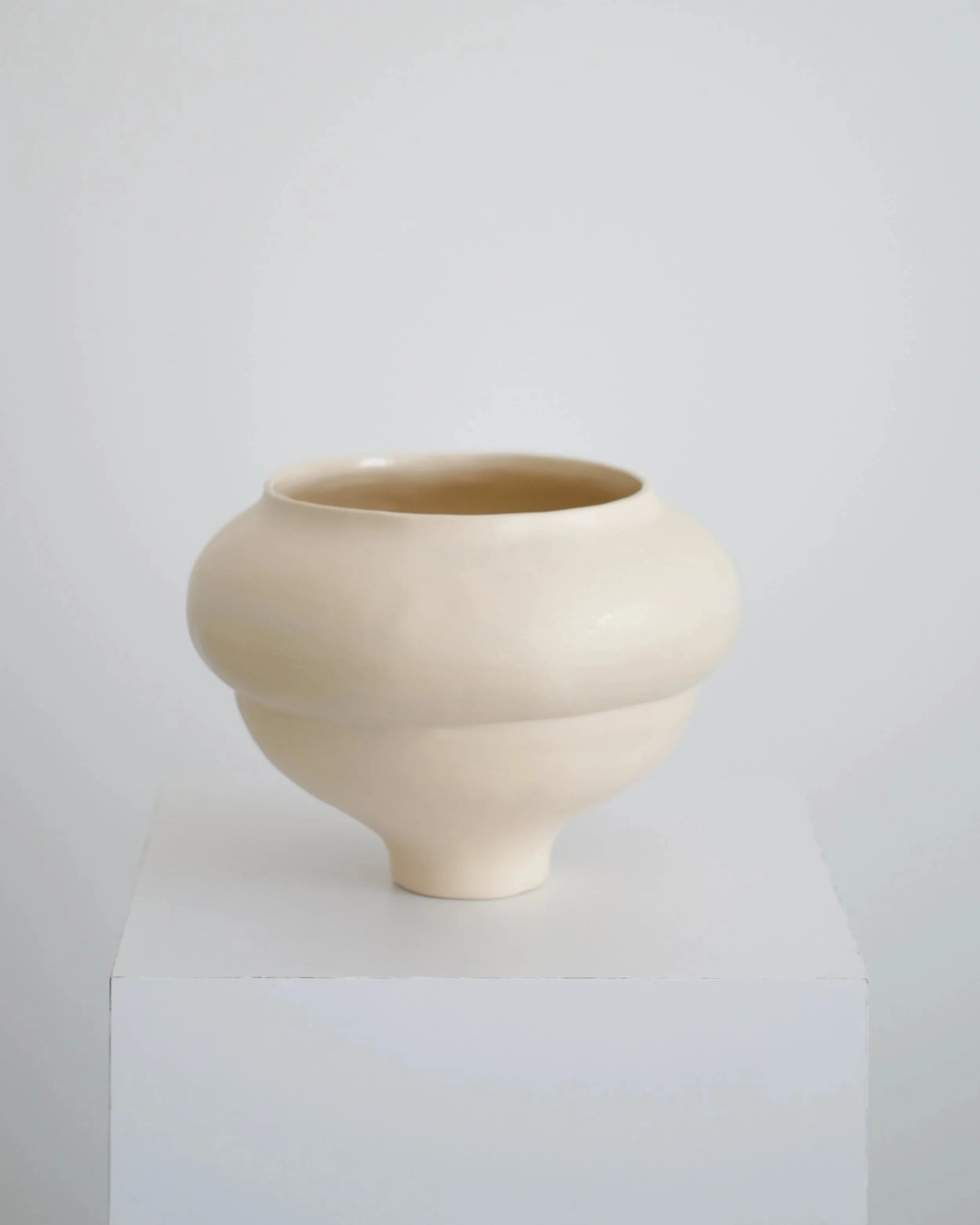 Cream hand-coiled Ampla stoneware vase on a pedestal, by SOIO Studio