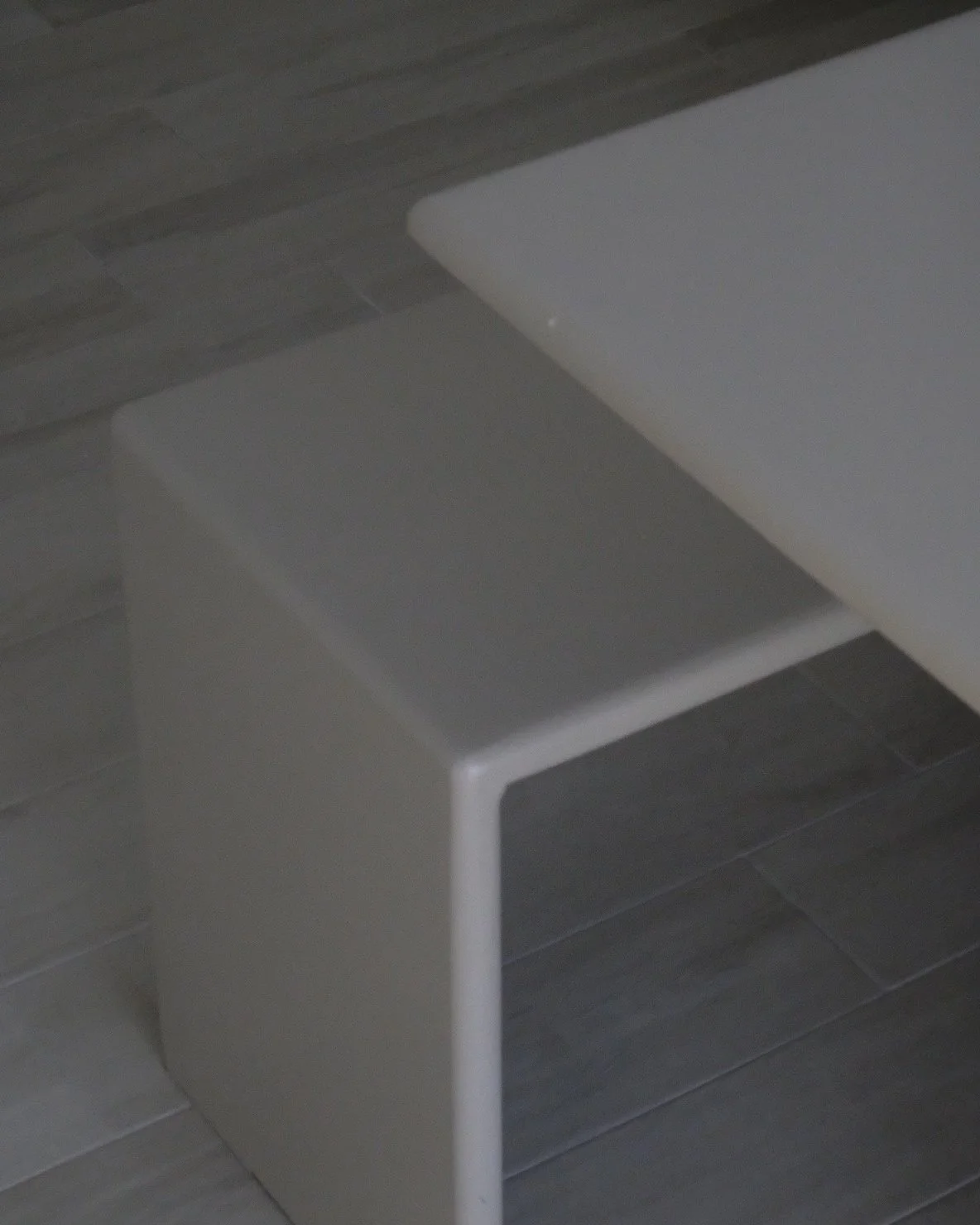 Belka iroko wood table by SOIO Studio, in a dark-floored room