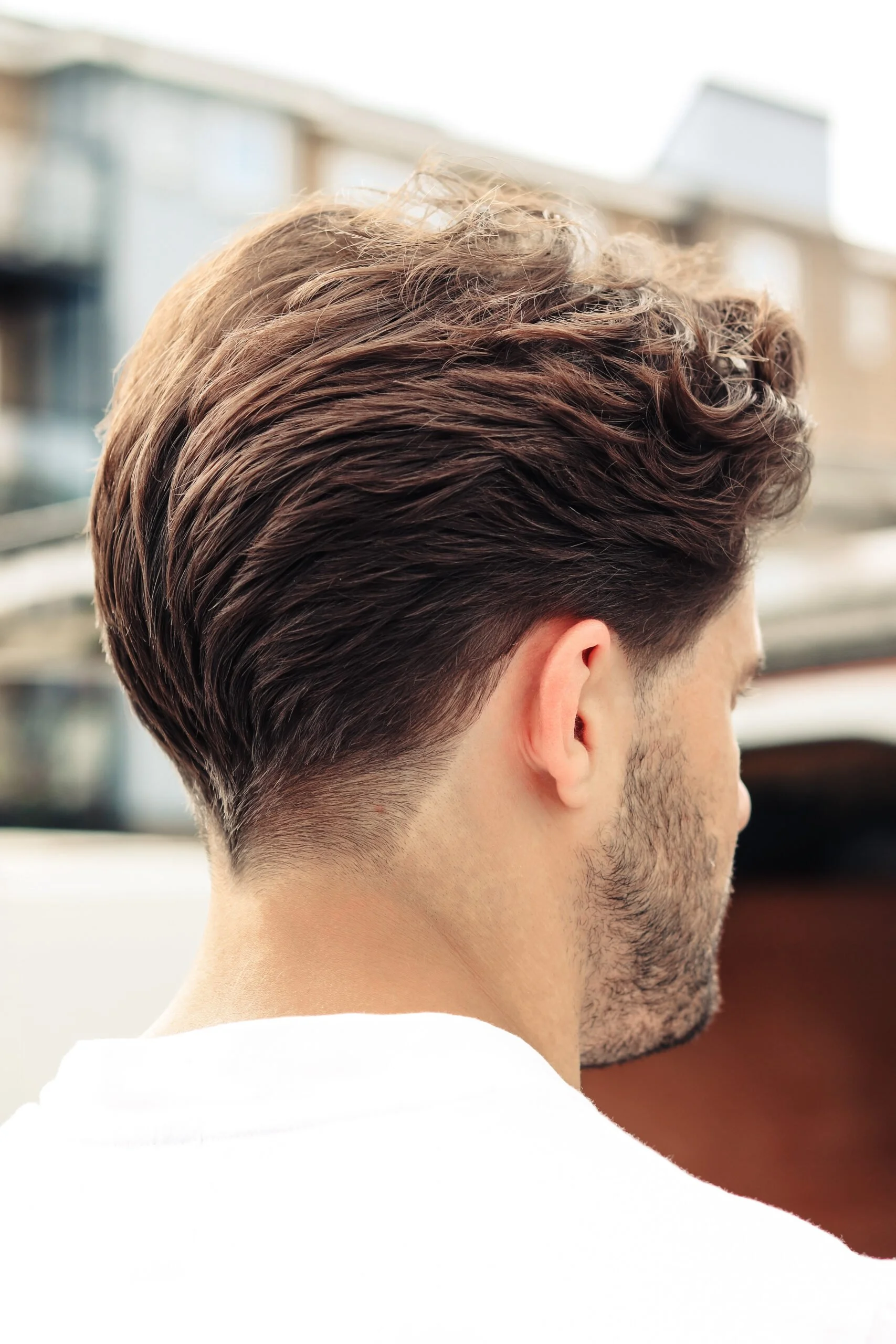 The back of a man's head, showcasing a slicked back men's haircut