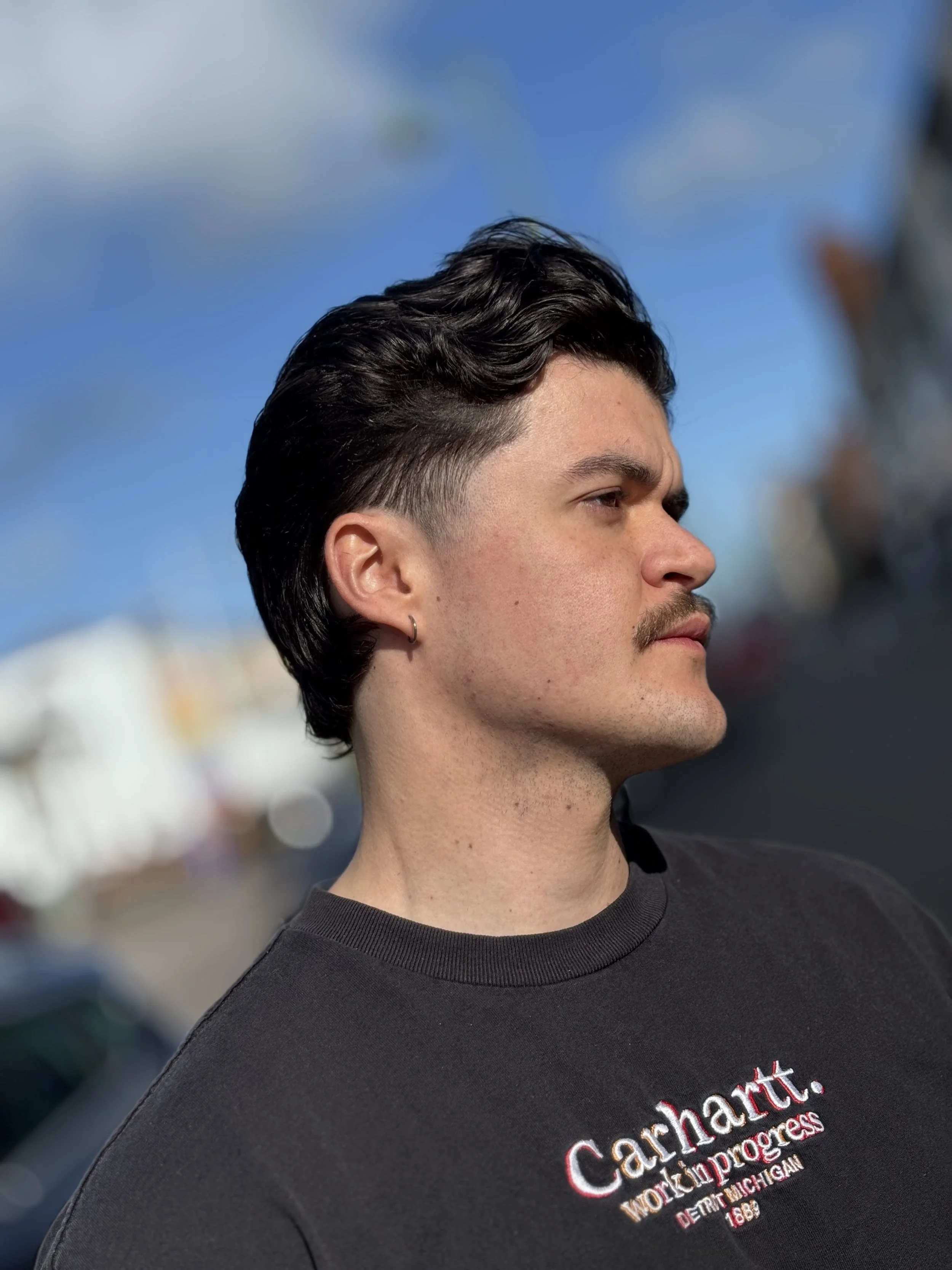Man with a moustache and a fresh haircut, taken on the street outside the barber shop in Shirley