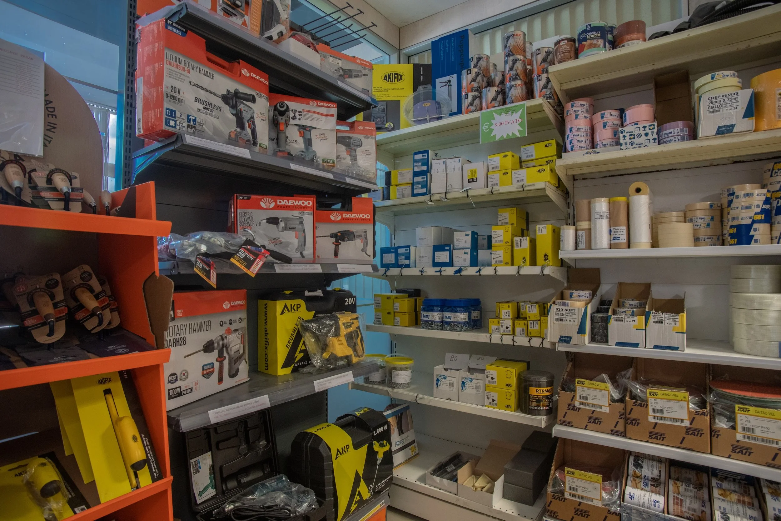 Scaffale di ferramenta con attrezzi elettrici, vernici e materiali di consumo