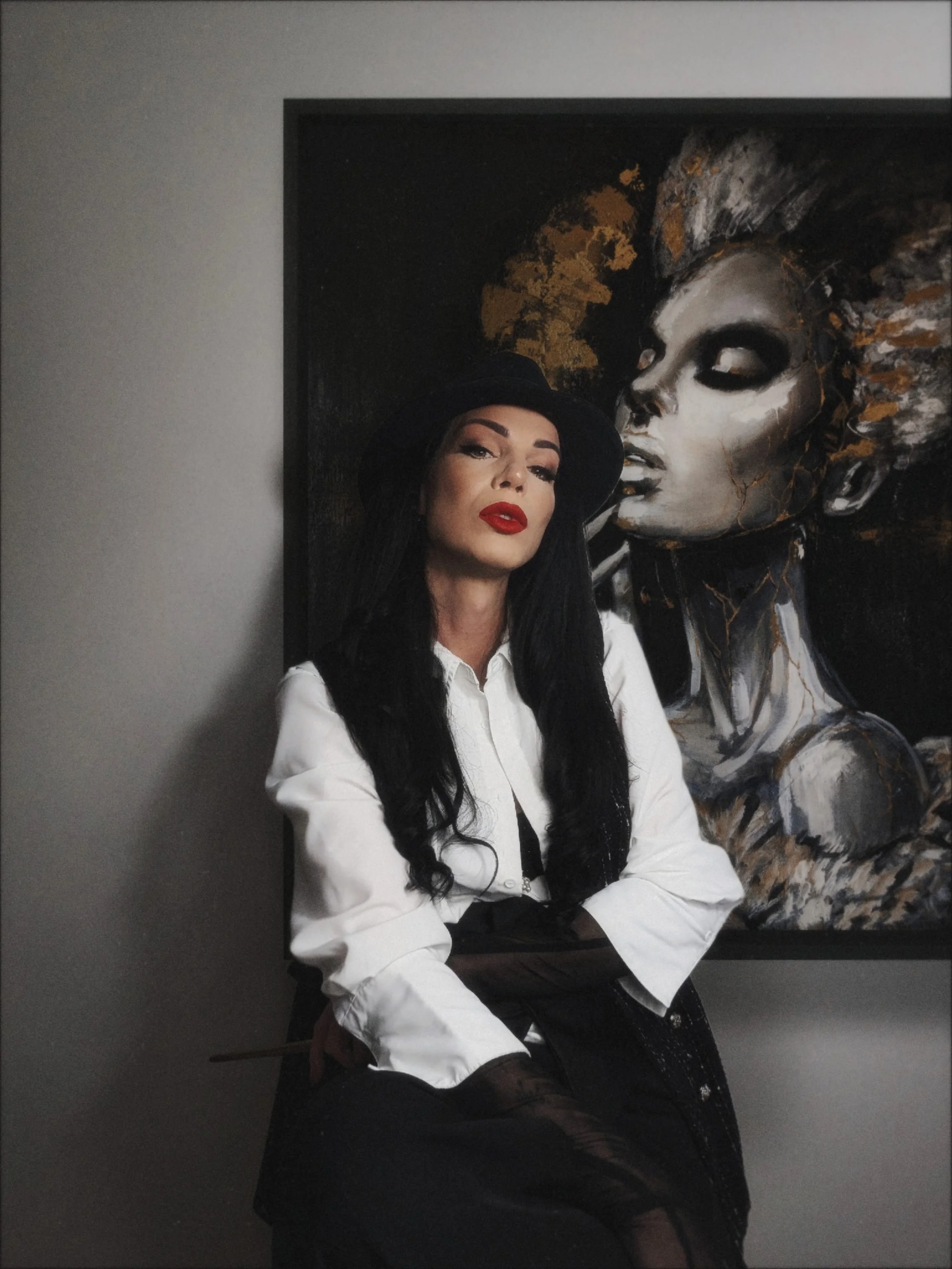 Medusa Divine Art posant avec son œuvre originale Silent Scar, portrait d’artiste peintre contemporaine.