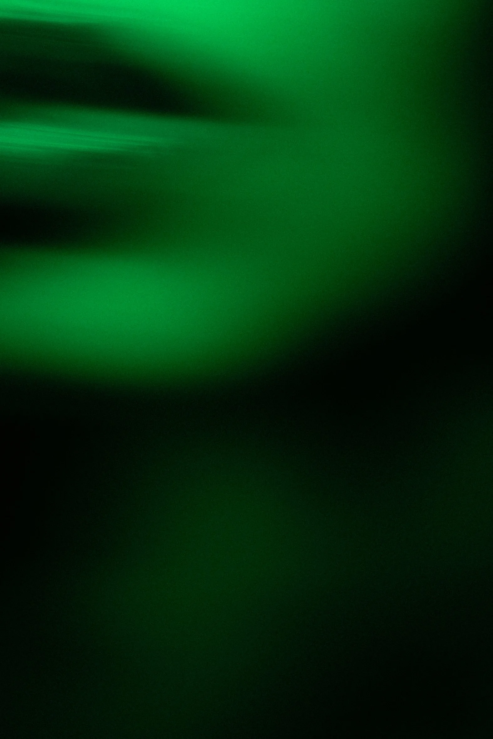 Luzes verdes abstratas em fundo escuro, criando um efeito de movimento.