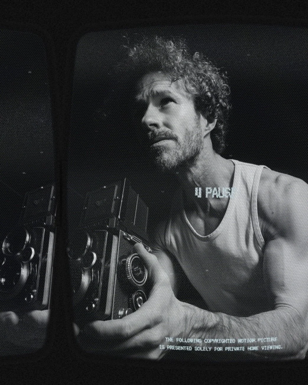 Homem segurando uma câmera vintage em uma imagem em preto e branco.